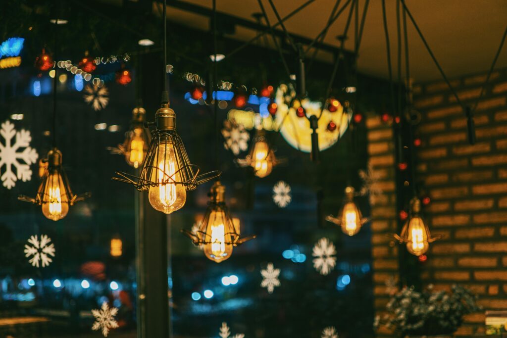 Warm and festive cafe ambiance with hanging bulbs and snowflake decorations.